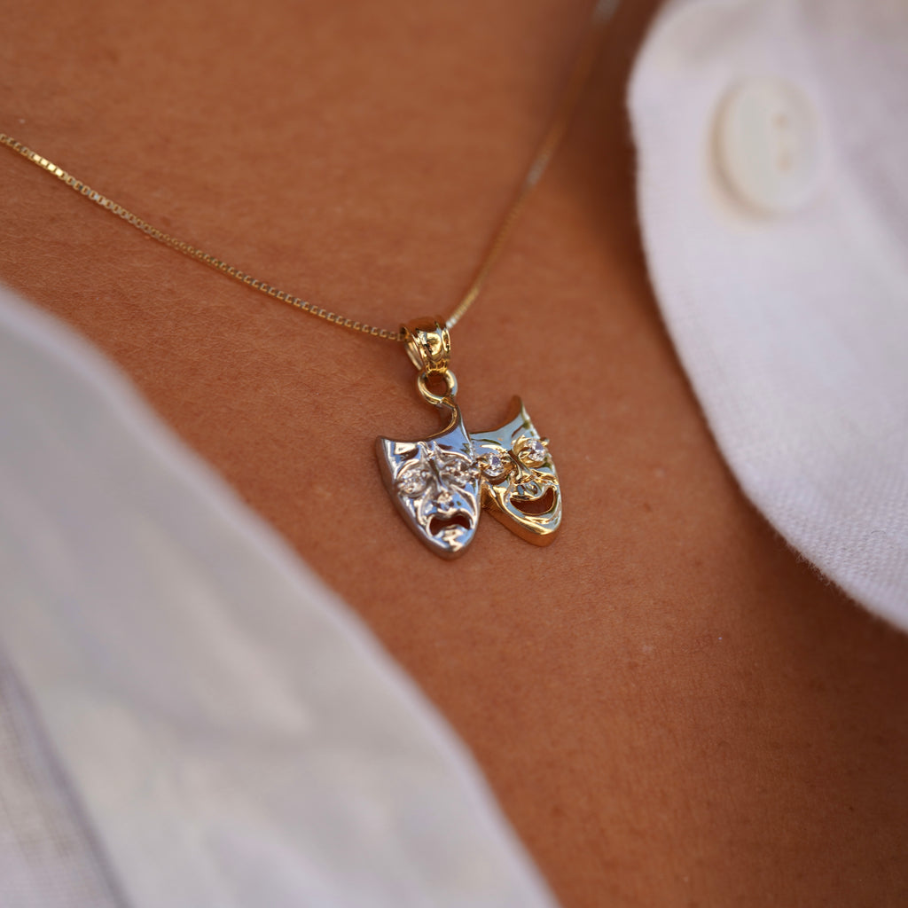 Side view of model wearing 14K Two-Tone Solid Gold Comedy & Tragedy Charm, displaying intricate details of the theater mask in two-tone gold.