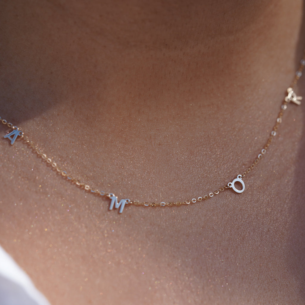Model wearing the 14K Gold AMOR Necklace, highlighting its elegant scripted 'AMOR' design, dainty gold chain, and adjustable fit for versatile styling.
