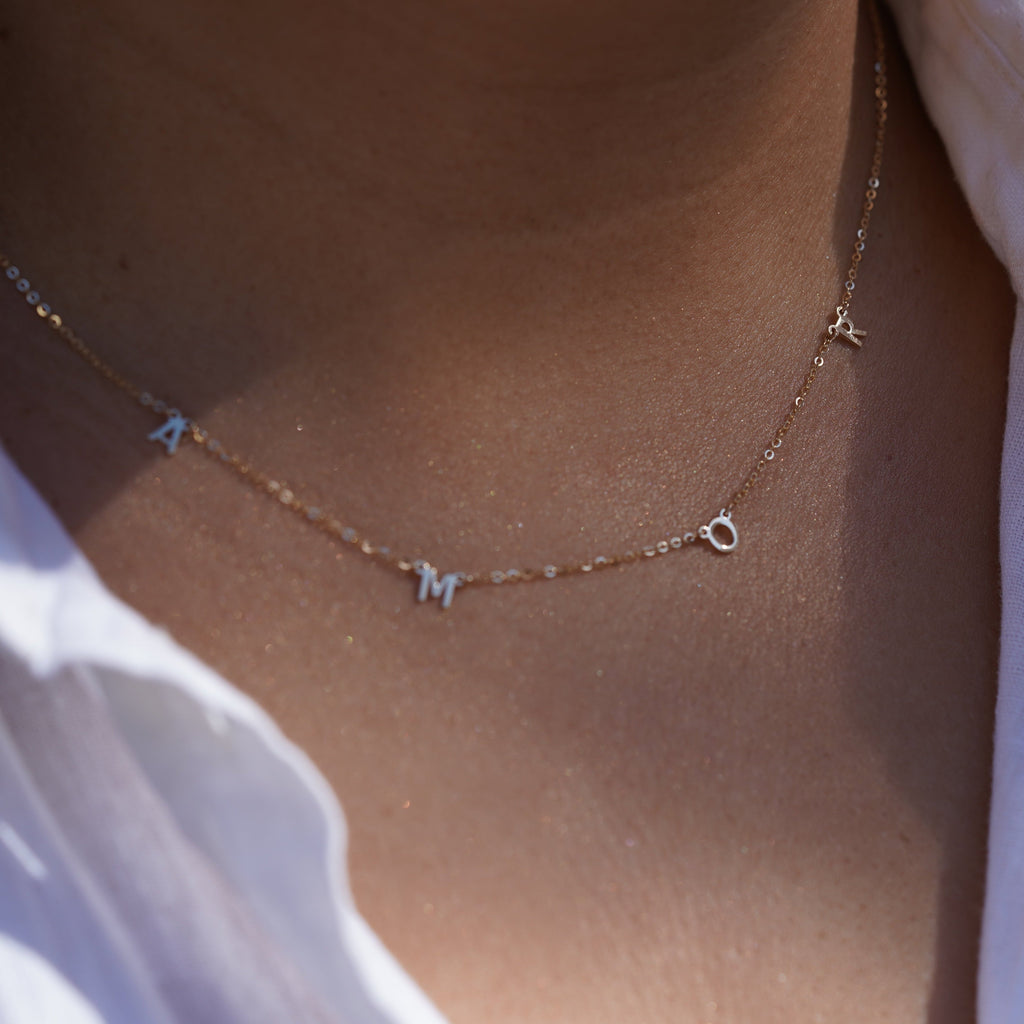 Model wearing the 14K Gold AMOR Necklace, highlighting its elegant scripted 'AMOR' design, dainty gold chain, and adjustable fit for versatile styling.