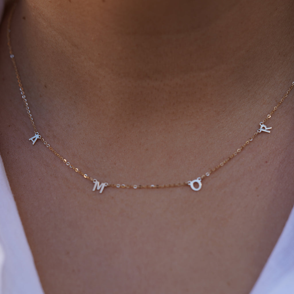 Model wearing the 14K Gold AMOR Necklace, highlighting its elegant scripted 'AMOR' design, dainty gold chain, and adjustable fit for versatile styling.