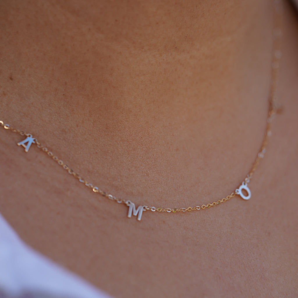 Model wearing the 14K Gold AMOR Necklace, highlighting its elegant scripted 'AMOR' design, dainty gold chain, and adjustable fit for versatile styling.