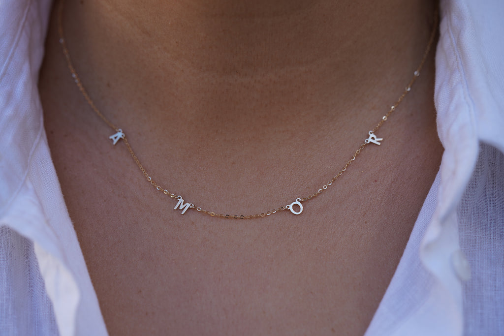 Model wearing the 14K Gold AMOR Necklace, highlighting its elegant scripted 'AMOR' design, dainty gold chain, and adjustable fit for versatile styling.