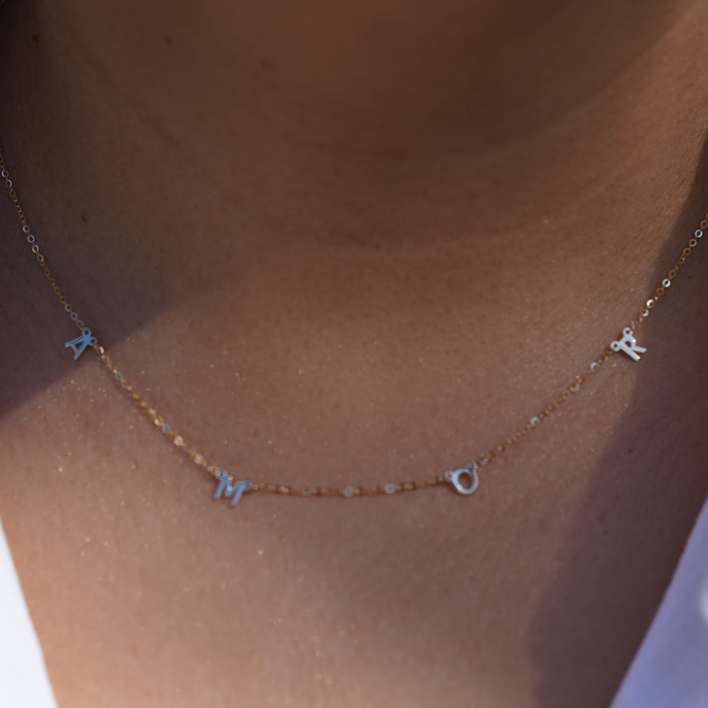 Model wearing the 14K Gold AMOR Necklace, highlighting its elegant scripted 'AMOR' design, dainty gold chain, and adjustable fit for versatile styling.