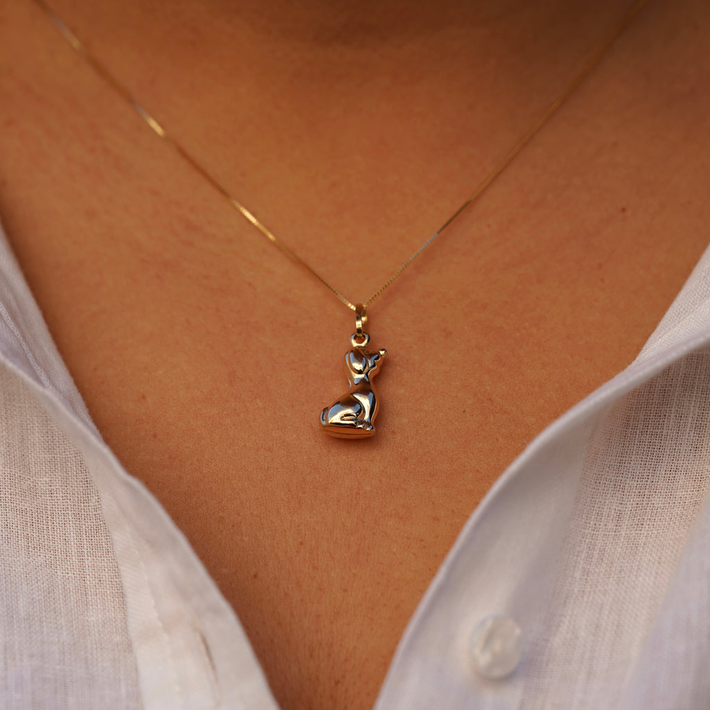 Model wearing the 14K Gold Dog Charm Pendant on a necklace, highlighting its polished finish and elegant canine design.