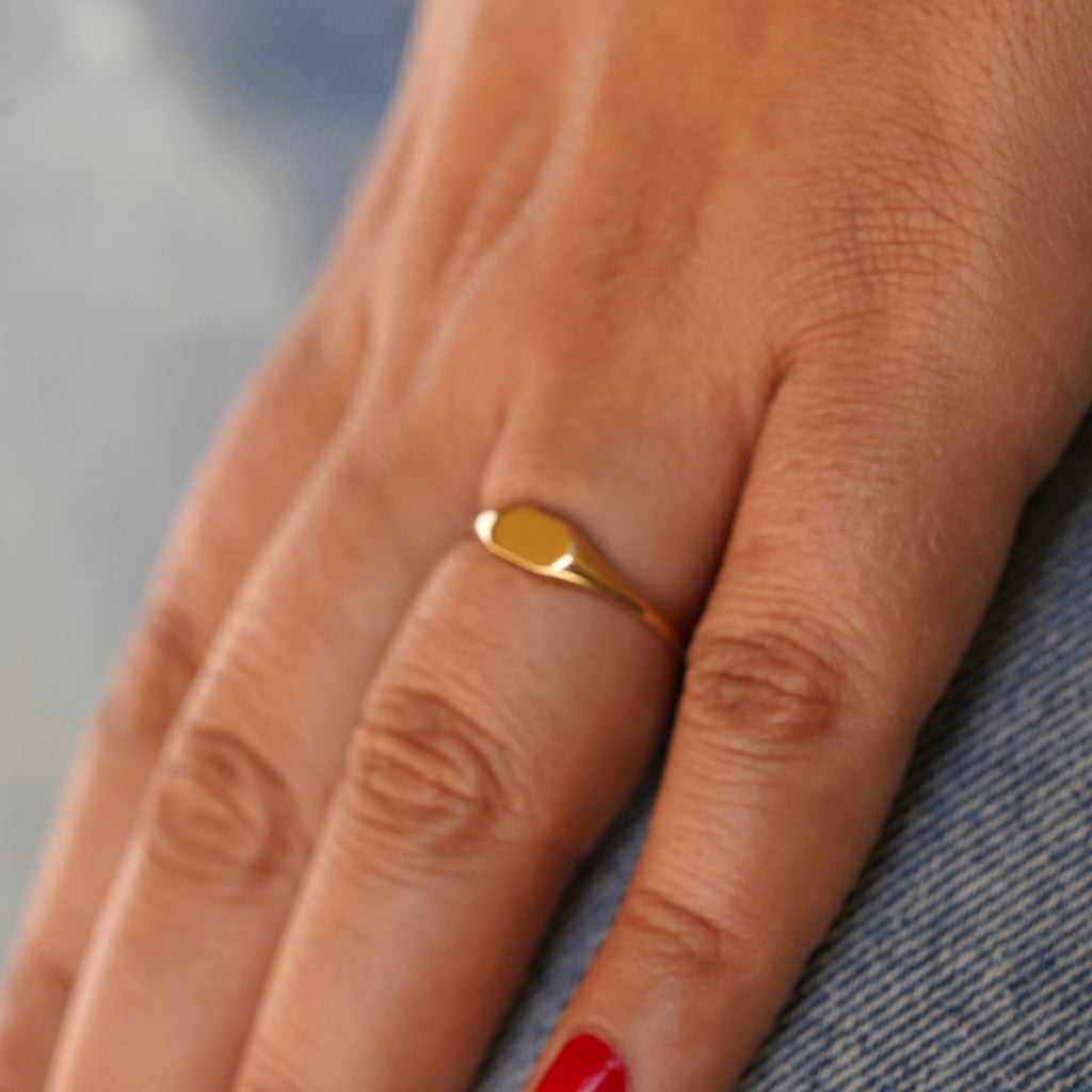 Model wearing a 14K Solid Gold Signet Ring, capturing its classic design and radiant gold finish in a sophisticated setting.