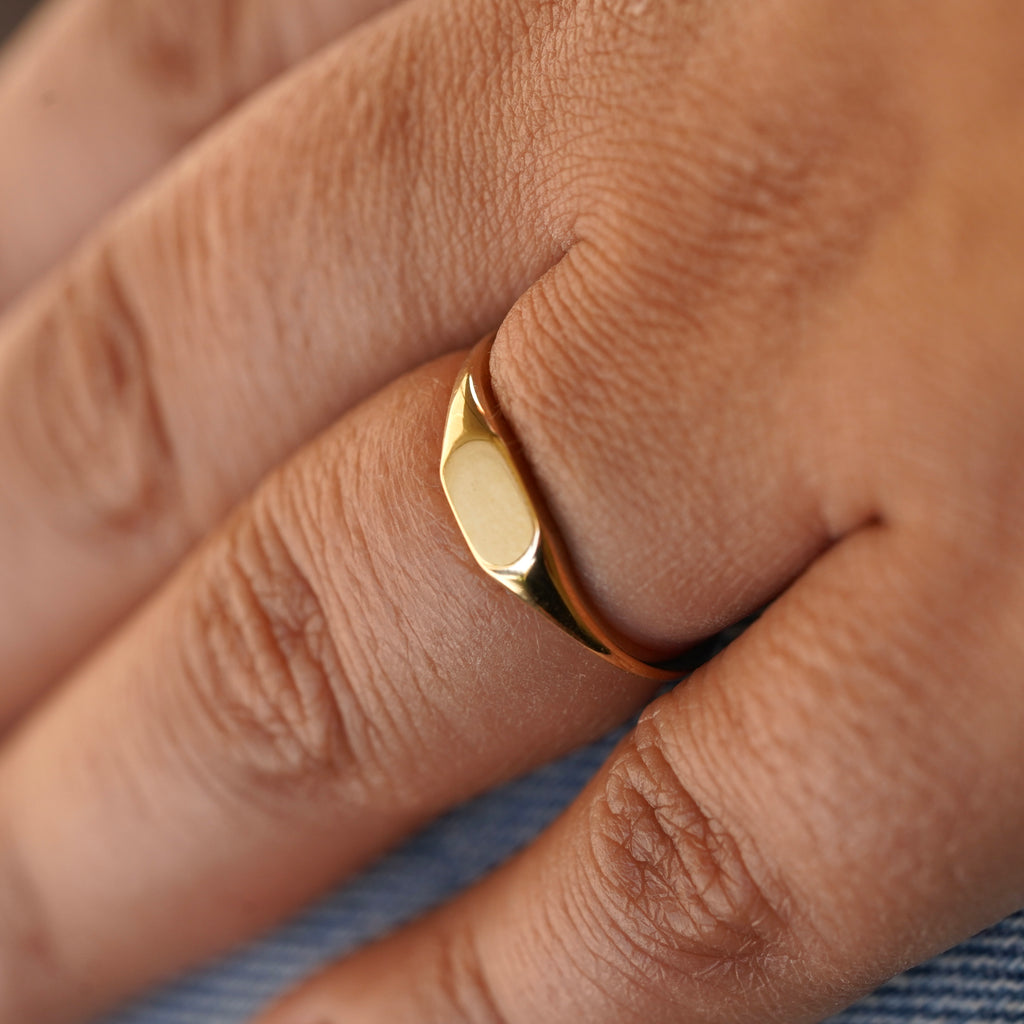 Close-up side angle of a model wearing a 14K Solid Gold Signet Ring, emphasizing its smooth edges and timeless craftsmanship against a natural hand pose.