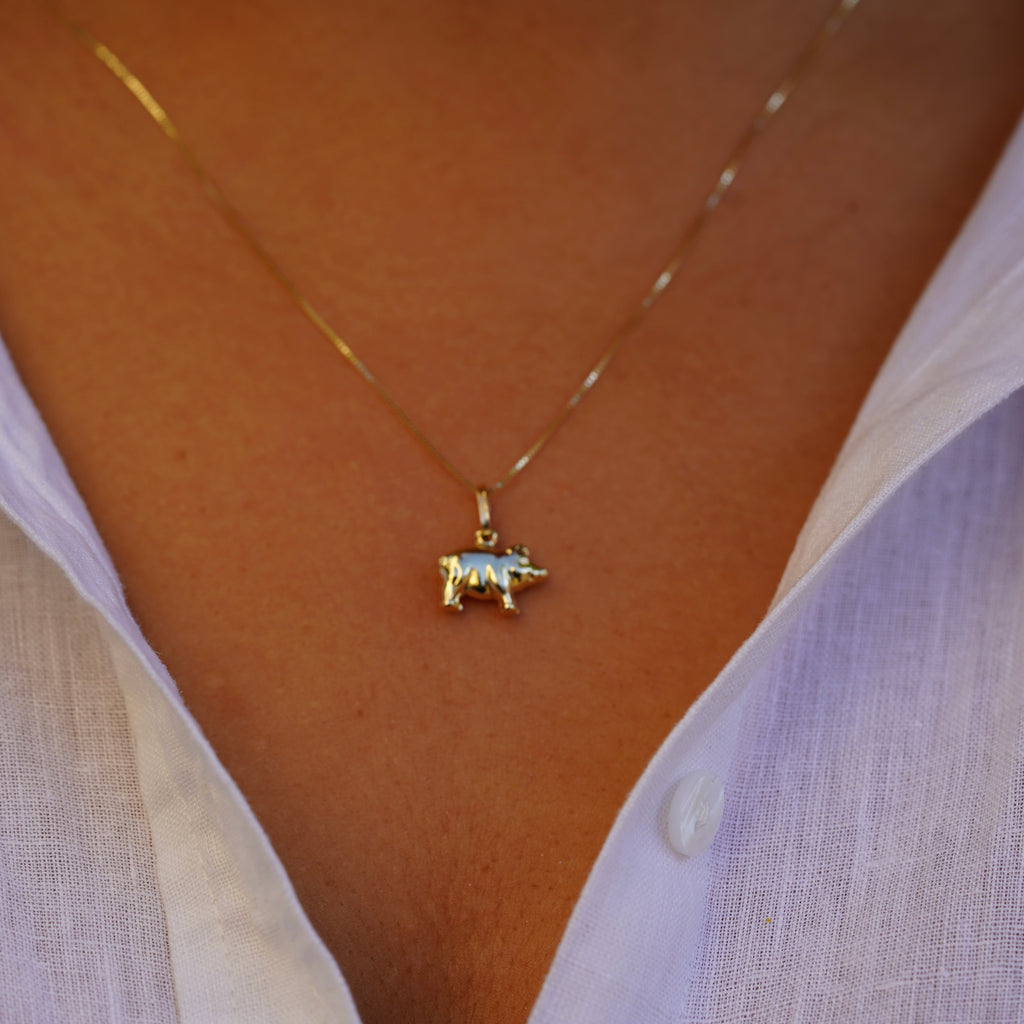 Step-back shot of a model wearing the 14K Solid Gold Pig Charm, showing the charm's elegant presence on a gold chain.