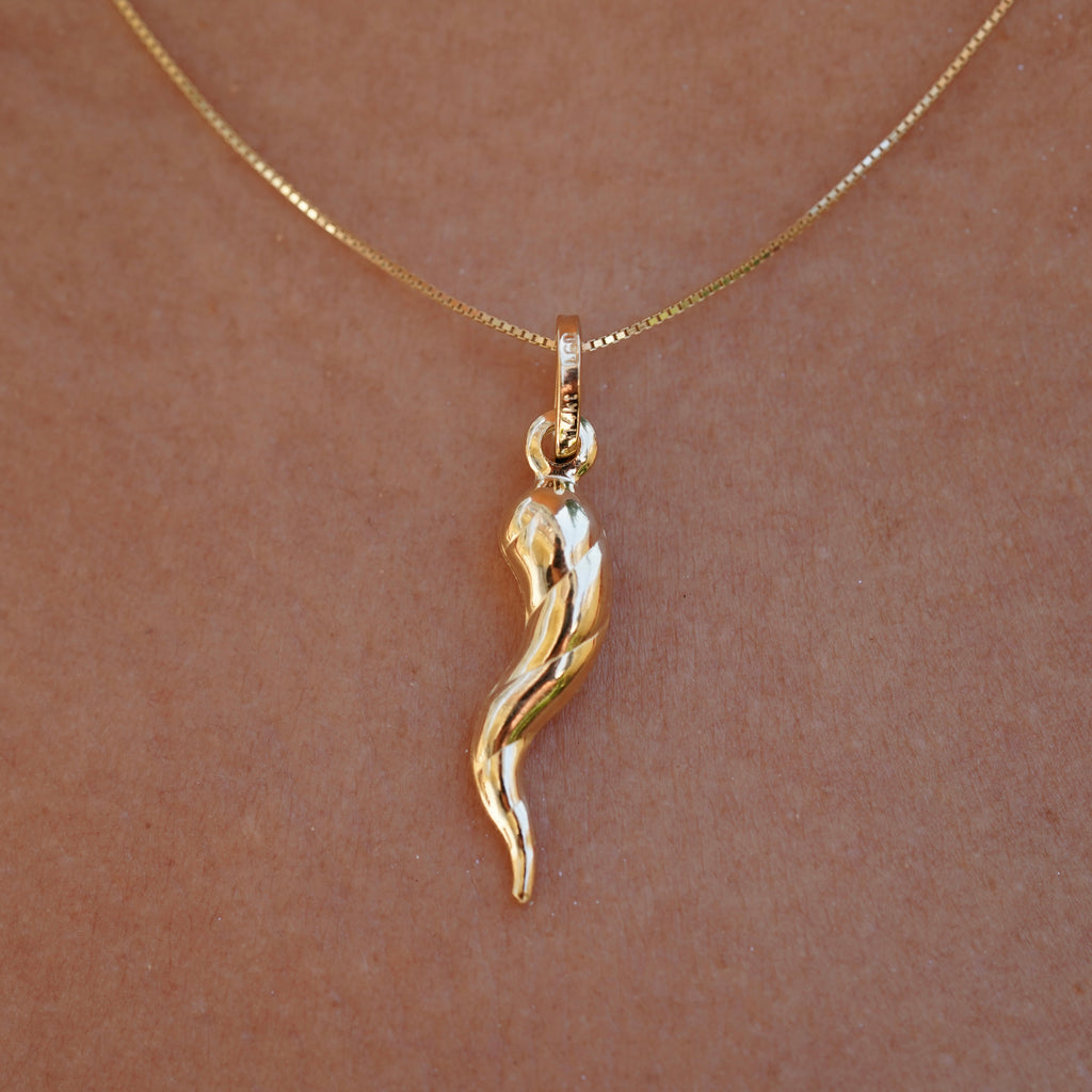 Close-up of 14K Real Gold Twisted Cornicello Italian Horn Charm worn by a model, front view.