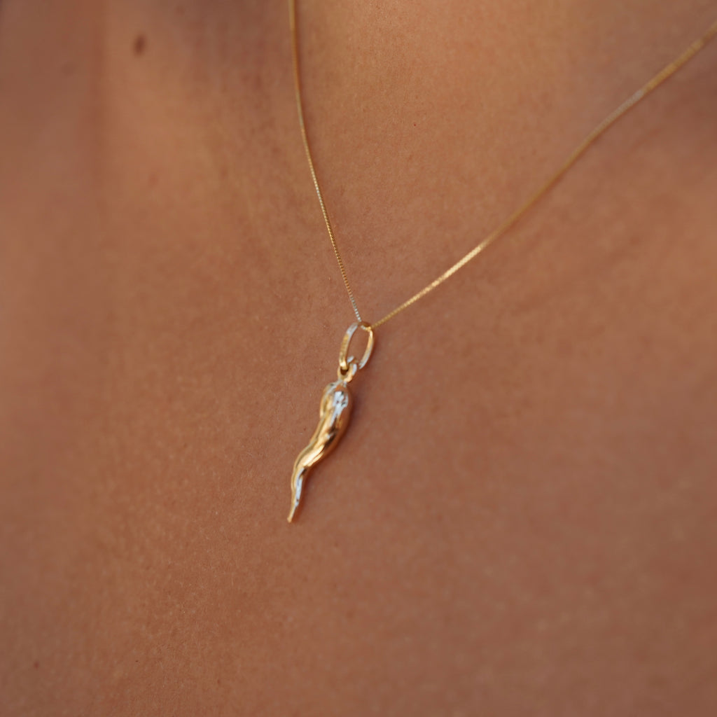 14K Real Gold Twisted Cornicello Italian Horn Charm worn by a model, right side view.