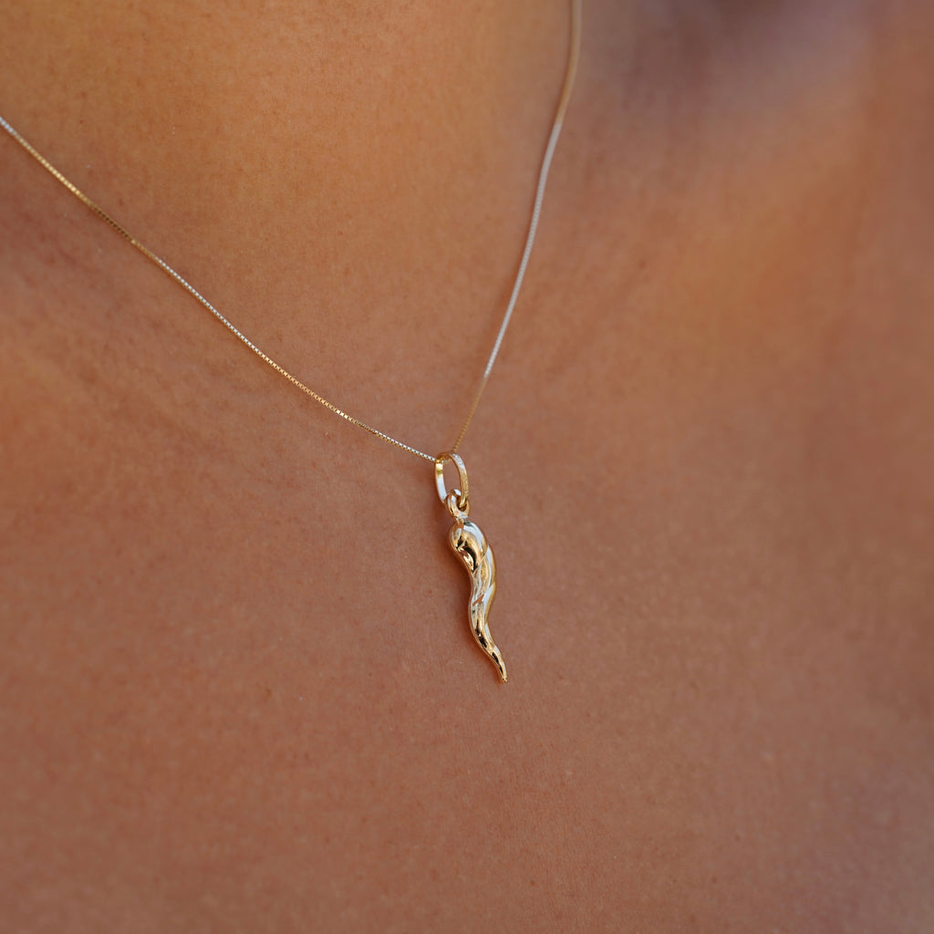 14K Real Gold Twisted Cornicello Italian Horn Charm worn by a model, left side view.