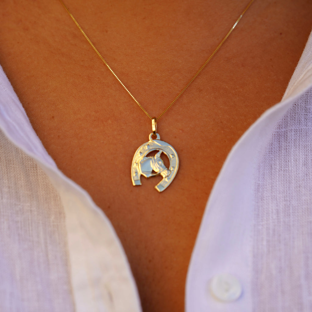 Step-back view of a model wearing the 14K Solid Gold Horse with Horseshoe Pendant, showcasing the charm’s elegant appearance on a gold chain.