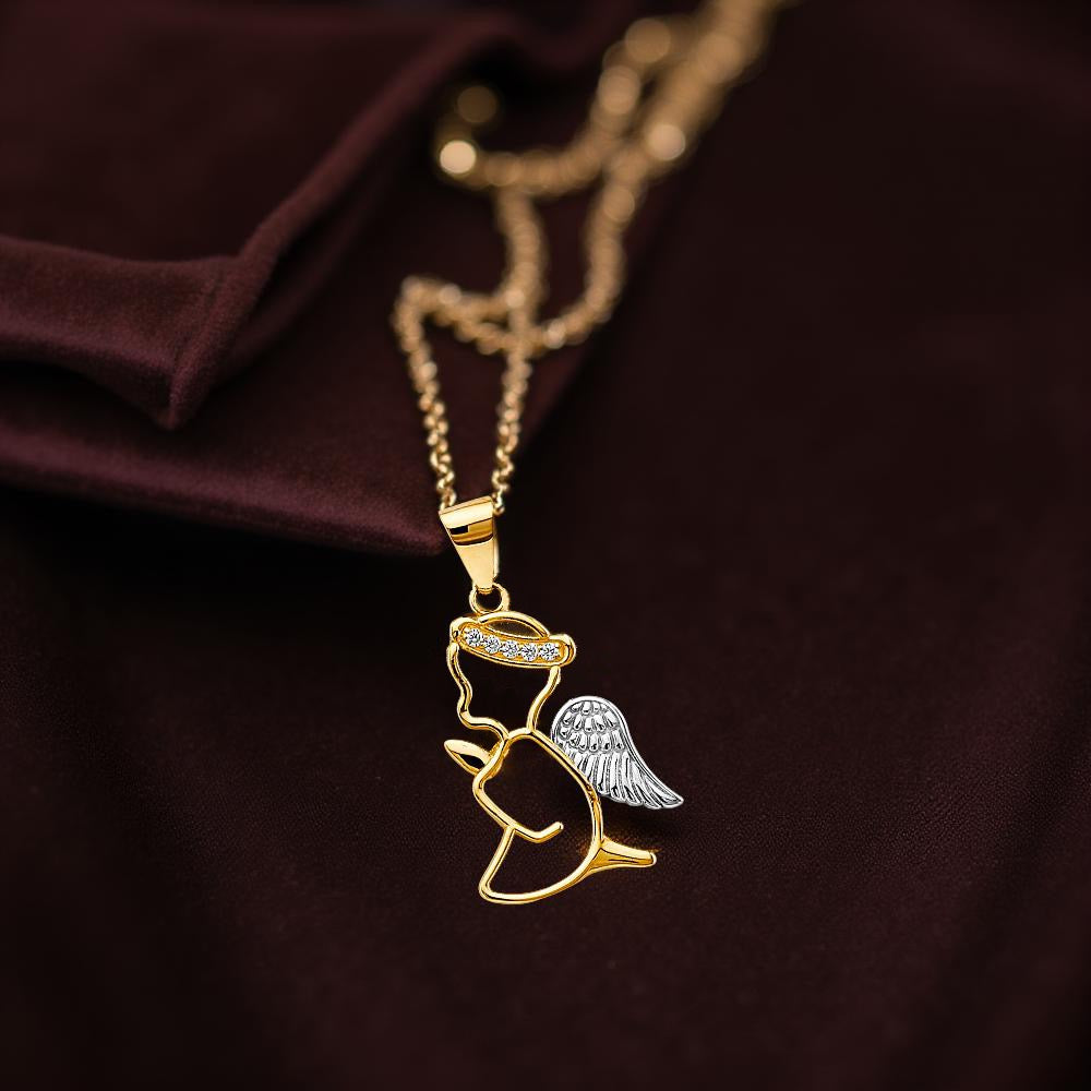 14K Two-Tone Gold Angel Pendant with CZ stones hanging from a delicate gold chain, elegantly styled on rich burgundy velvet for a luxurious, warm presentation.