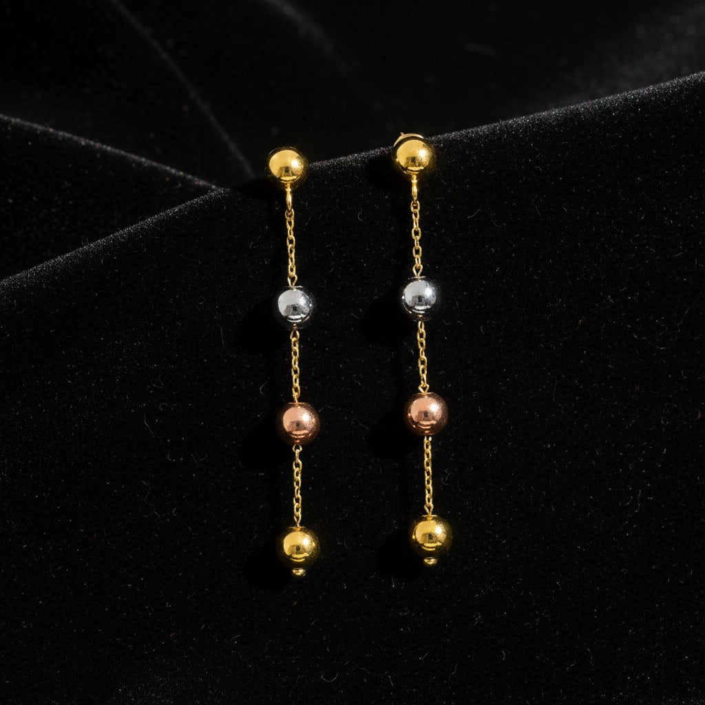 14K Tri-Color Gold Hanging Ball Earrings displayed on black velvet cloth, highlighting 3mm balls and 40mm drop in yellow, rose, and white gold.