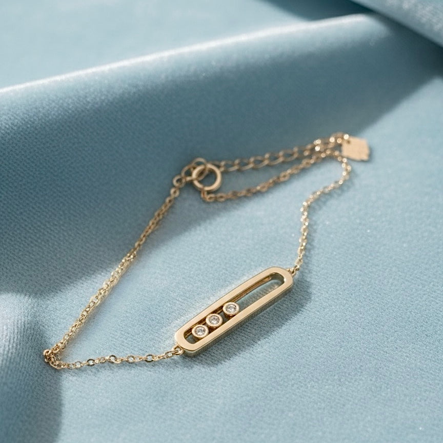 14K Yellow Gold CZ Center ID Bracelet laid on a light blue velvet cloth, highlighting the shiny gold ID bar and the sparkling CZ center.