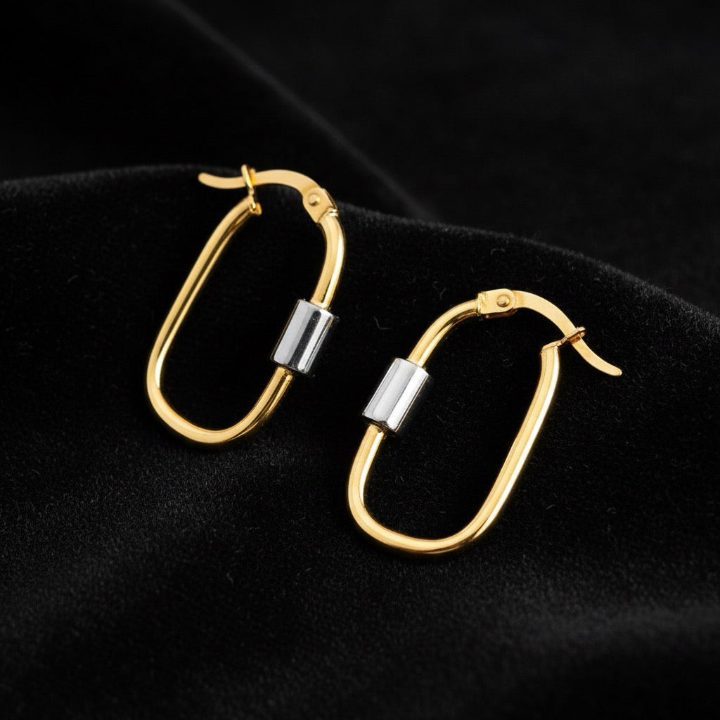14K two-tone U-shaped hoop earrings laid on soft black velvet, highlighting the contrast between yellow and white gold tones and the curved polished design.