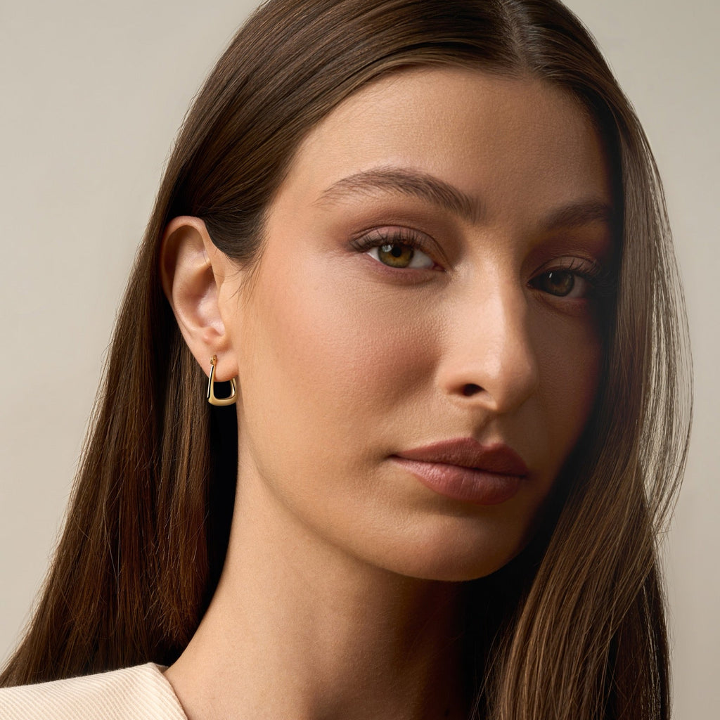 Model wearing 14K Yellow Gold Hollow Hoop Earrings, highlighting their lightweight, polished design and classic hoop style.