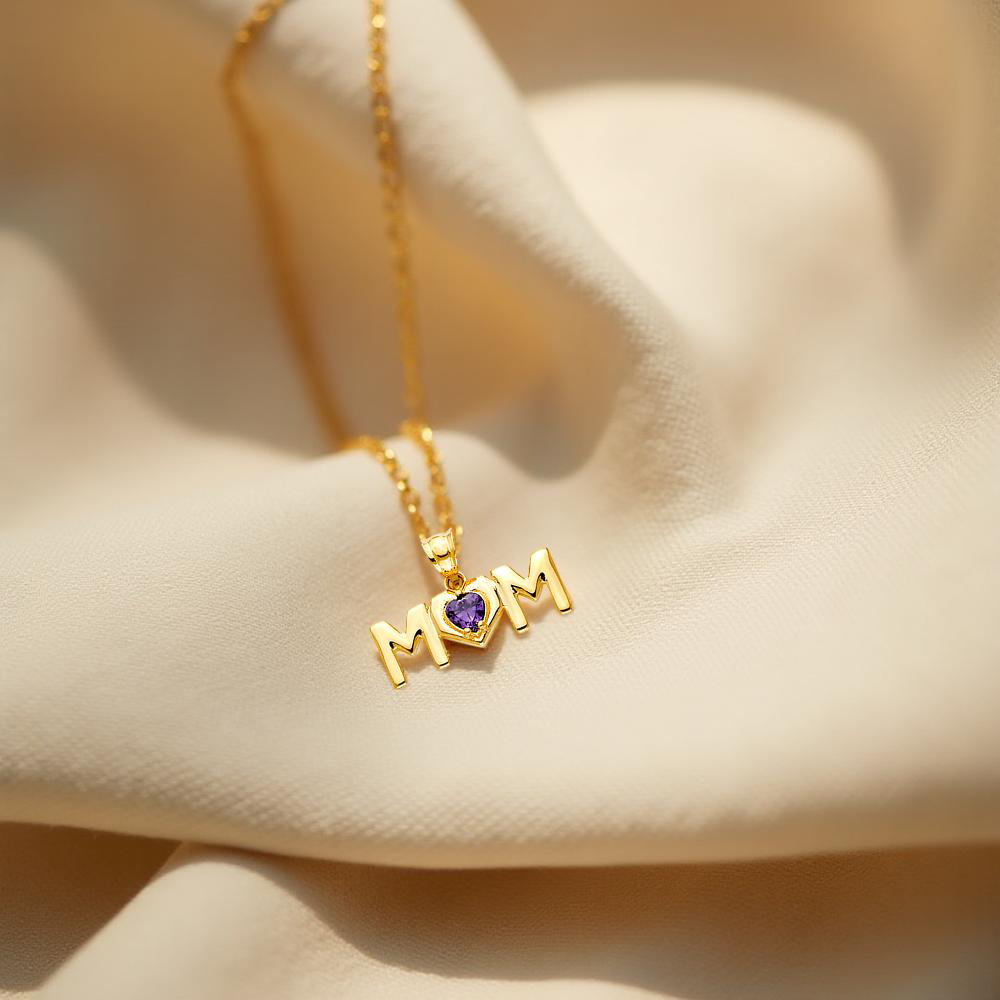 14K Yellow Gold MOM Pendant with CZ accents placed on an off-white textured cloth, showcasing its radiant sparkle and heartfelt design.