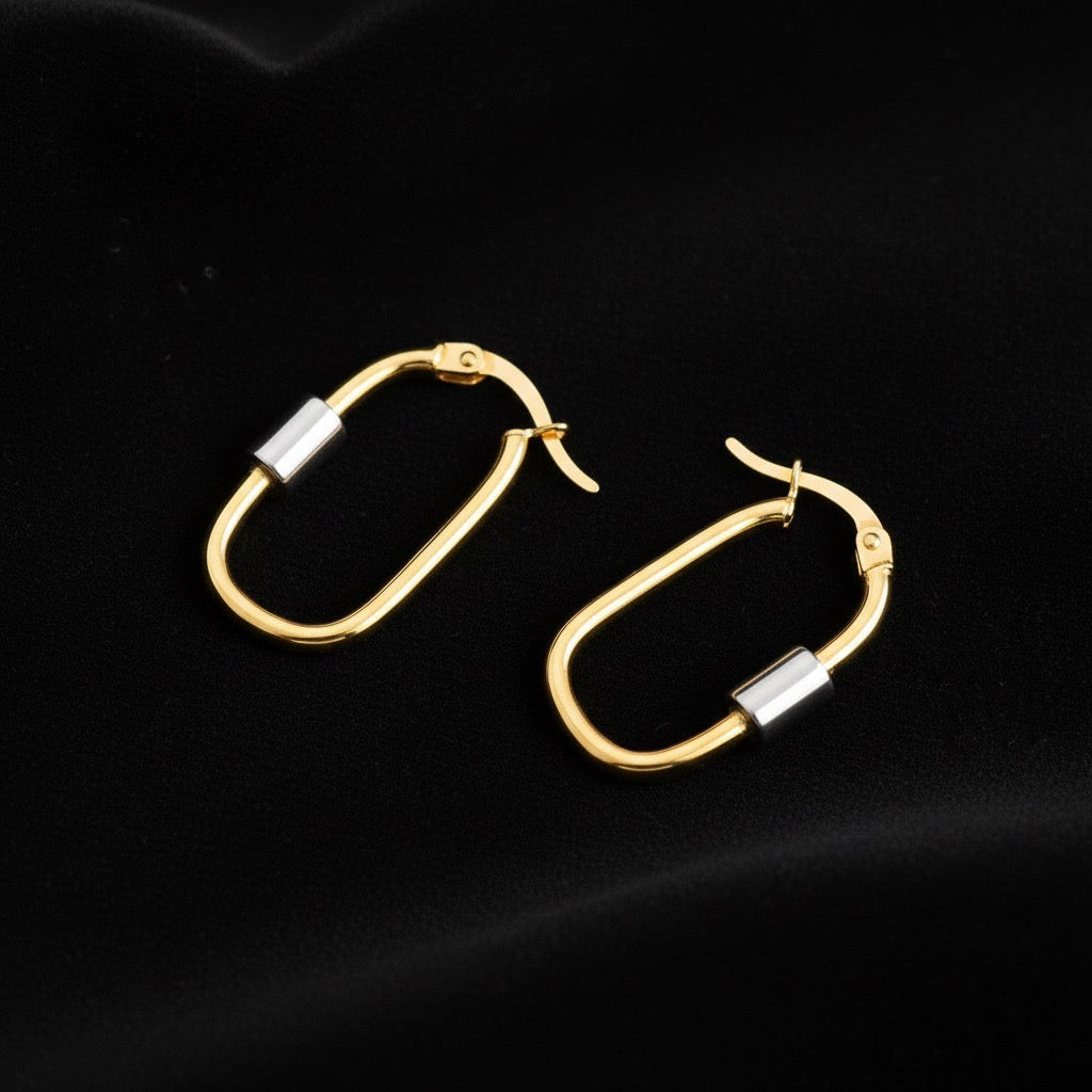 14K two-tone U-shaped hoop earrings laid on soft black velvet, highlighting the contrast between yellow and white gold tones and the curved polished design.