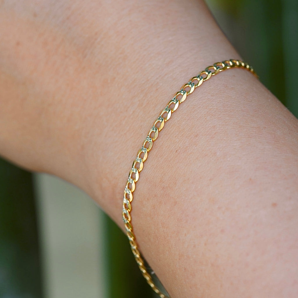 A model wearing the 3.2mm 14K Gold Cuban Link Bracelet with a white pave design, showcasing its elegant shine.