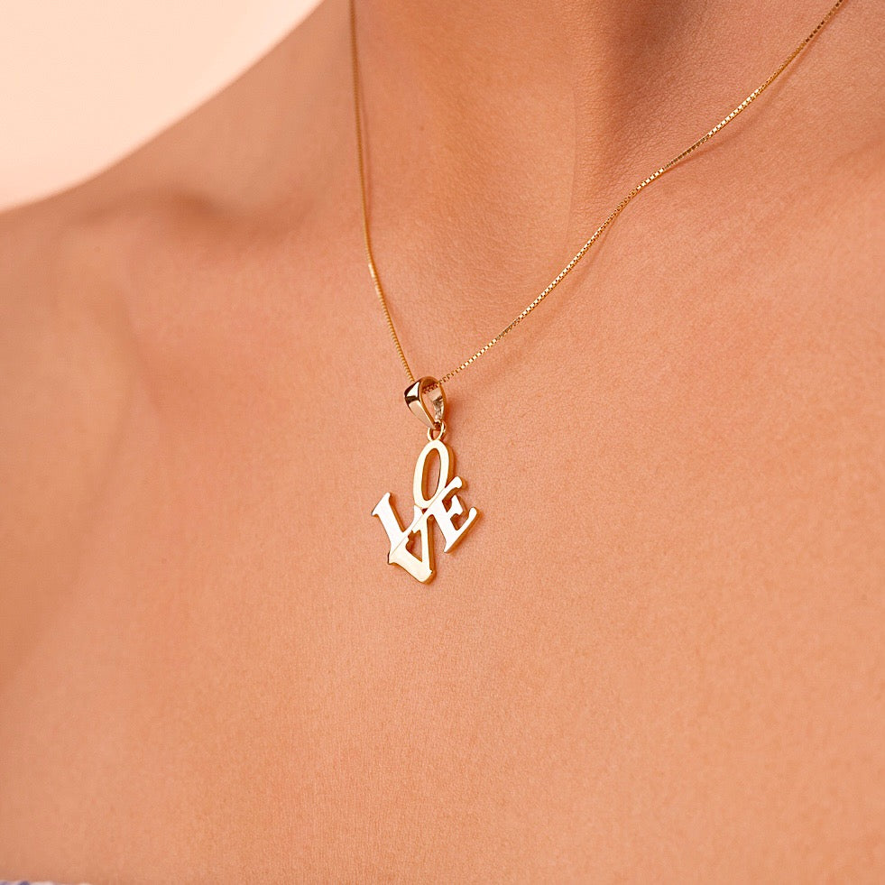 Model wearing the 14K gold two-tone Love charm as a necklace, illustrating its dainty size and romantic everyday elegance.