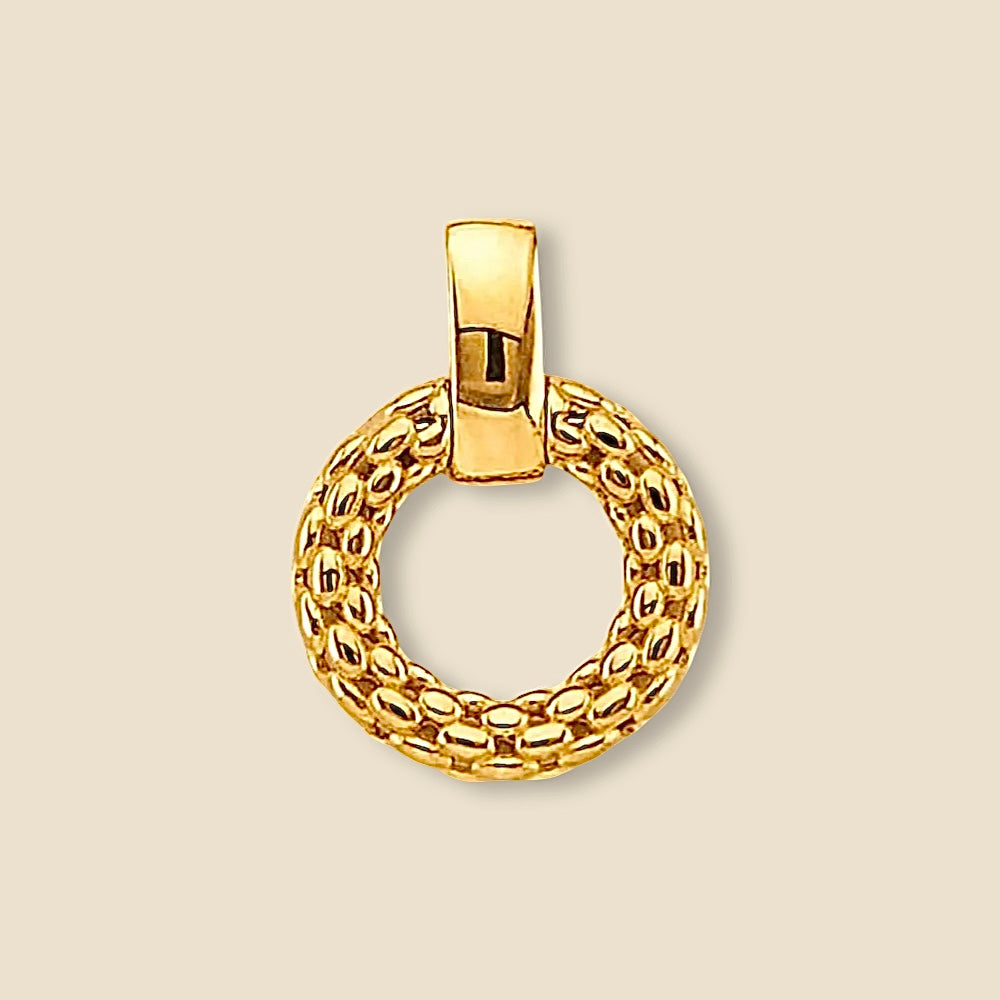 A close-up image of a 14K gold round mesh pendant, displayed against a plain background. The intricate filigree design and polished gold finish highlight its delicate craftsmanship and elegant details.