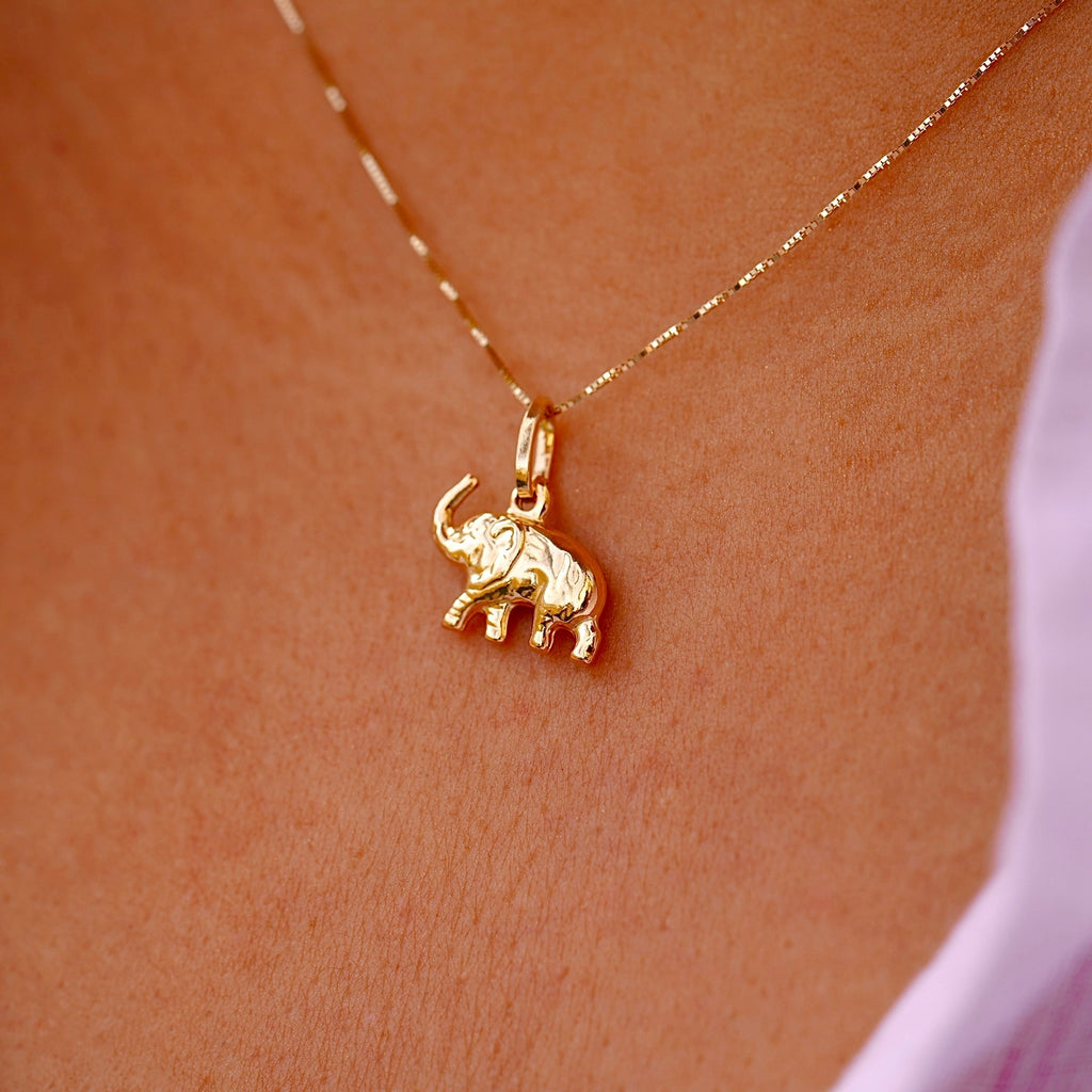 Model elegantly wears the 14K Gold Elephant Pendant on a delicate chain, highlighting its dainty size and sophisticated charm.