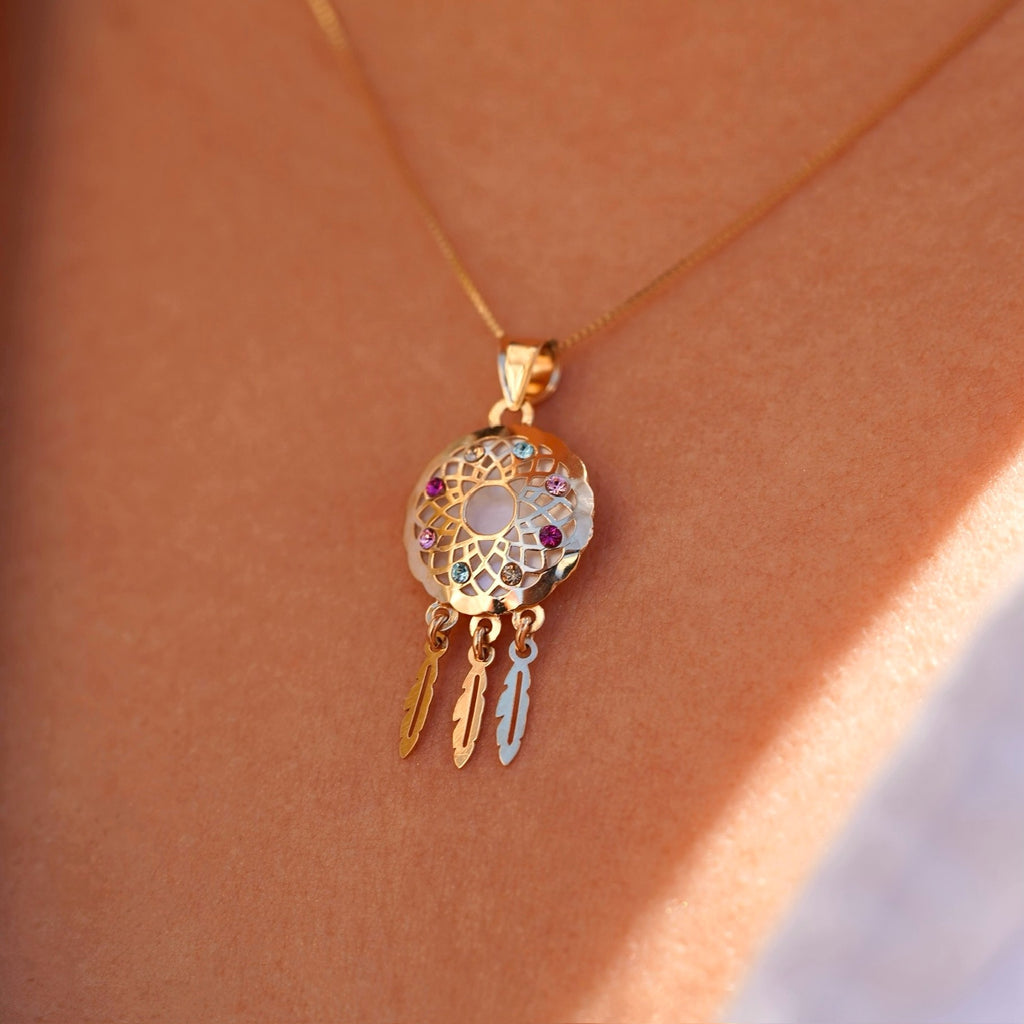 Model wearing a 14K yellow gold dreamcatcher pendant on a fine chain, the charm resting near the neckline, adding a touch of meaningful elegance and boho-inspired style.