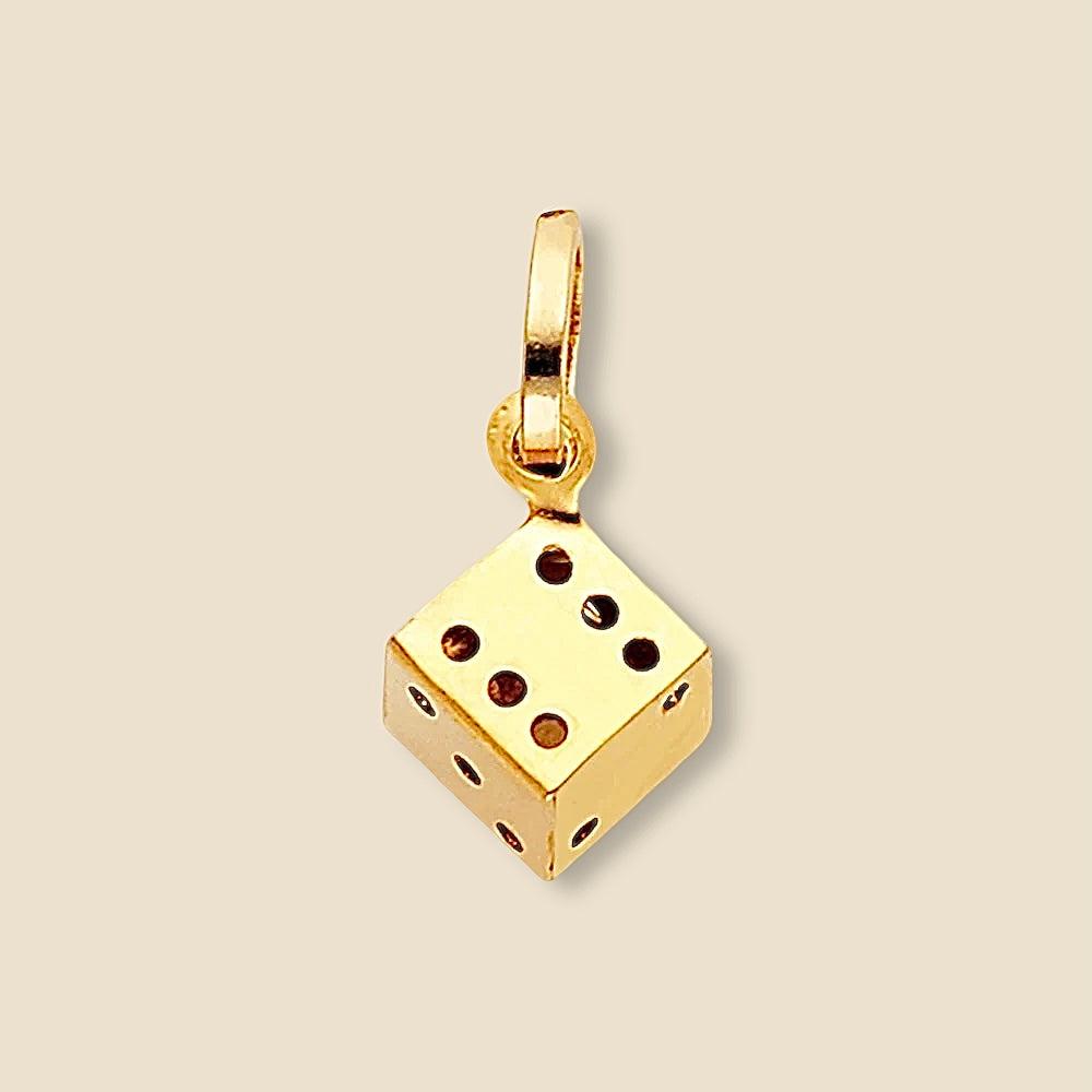A detailed close-up of the 14K Gold Dice Pendant taken from a side angle, highlighting its precise edges, smooth polished finish, and stamped authenticity mark.
