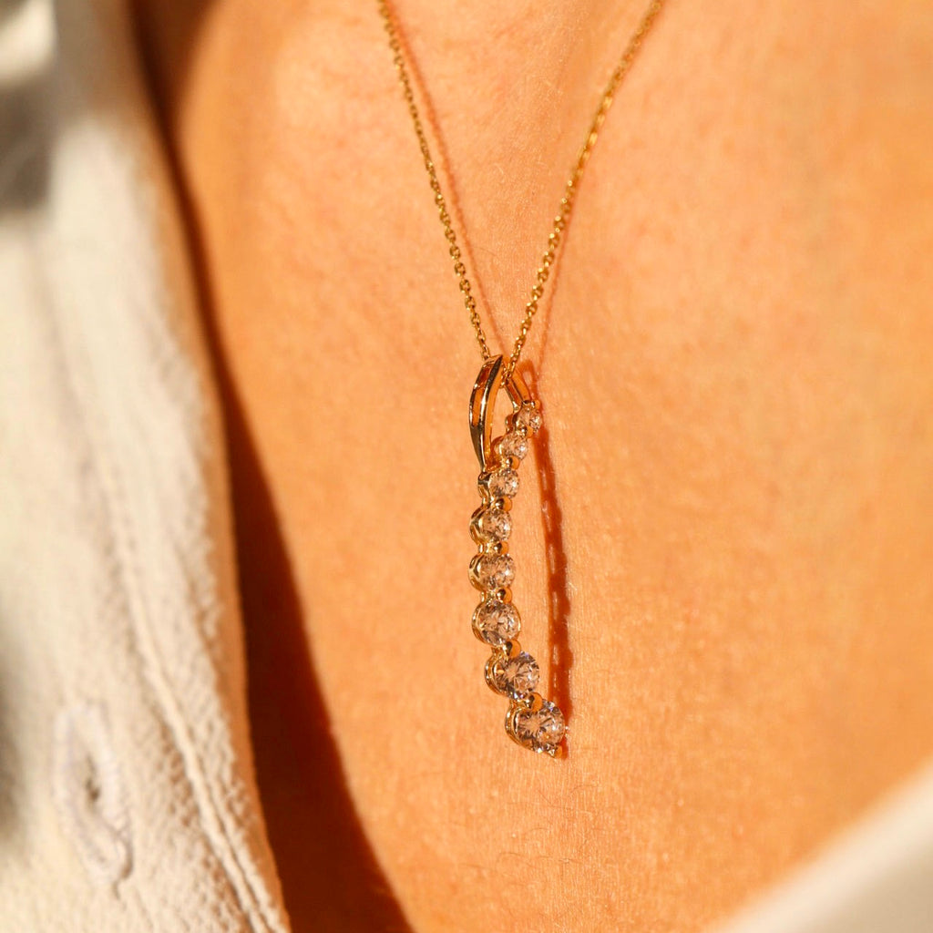A close-up of a model wearing a dainty 14K gold Italian horn pendant on a delicate chain, adding a touch of elegance and meaning to her outfit.