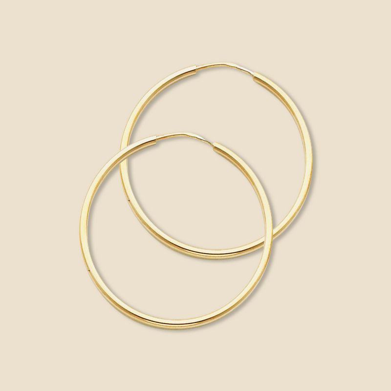 A close-up of the 14K Yellow Gold 1.5mm Round Tube Polished Endless Hoop Earrings (30mm) against a plain background, showcasing their sleek, polished finish and seamless hoop design.