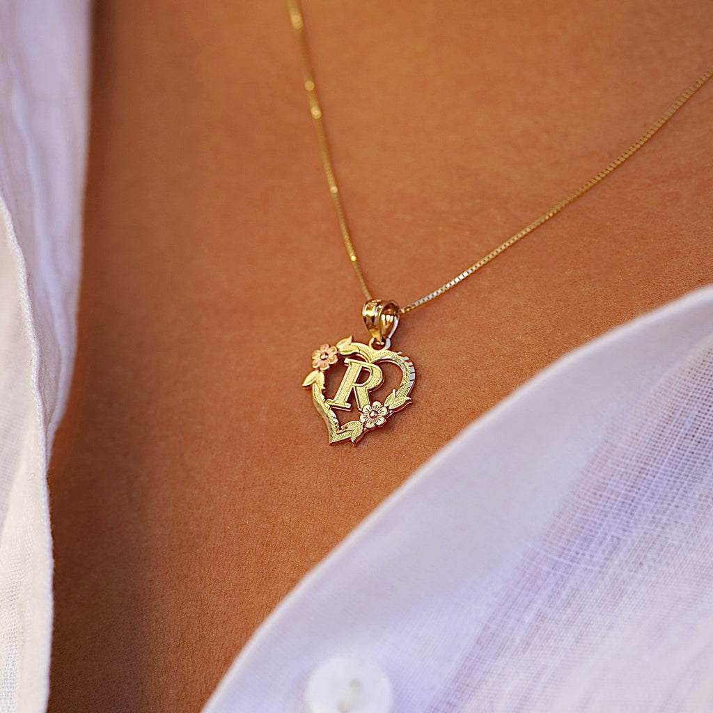 Model wearing the 14K Two-Tone Initial Heart Pendant with Letter R, highlighting the charm from the left side with elegant yellow and rose gold tones.