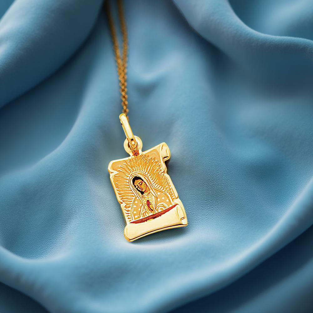 Large 14K solid gold Guadalupe Virgin Mary pendant (18mm x 13mm) displayed on a blue velvet cloth. The luxurious backdrop highlights the pendant's high-gloss finish and precise craftsmanship, making it a stunning religious keepsake with timeless appeal.
