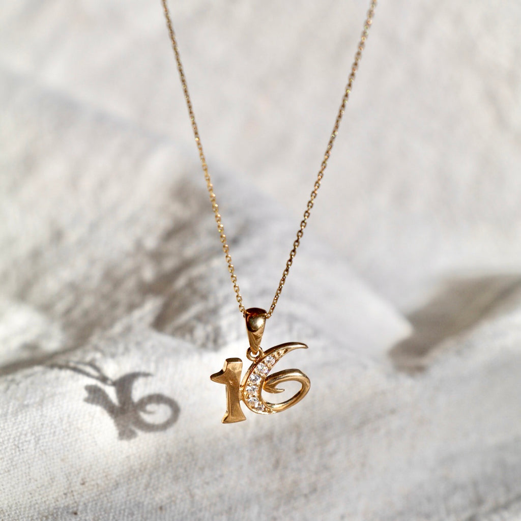 14K Solid Yellow Gold Sweet 16 Charm Pendant displayed against a white backdrop, highlighting its polished gold finish, elegant design, and intricate craftsmanship.