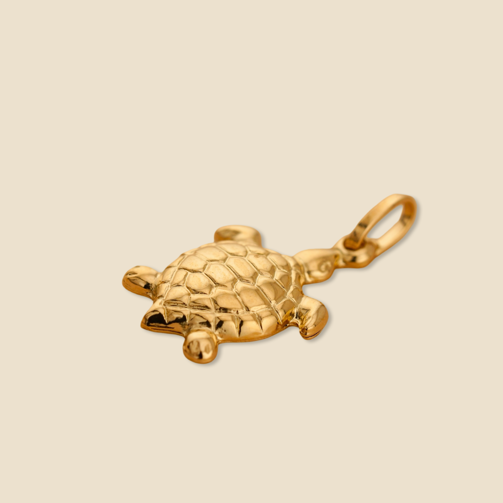 Close-up of 14K yellow gold turtle pendant on a plain background, showing its polished finish and intricate shell detailing.