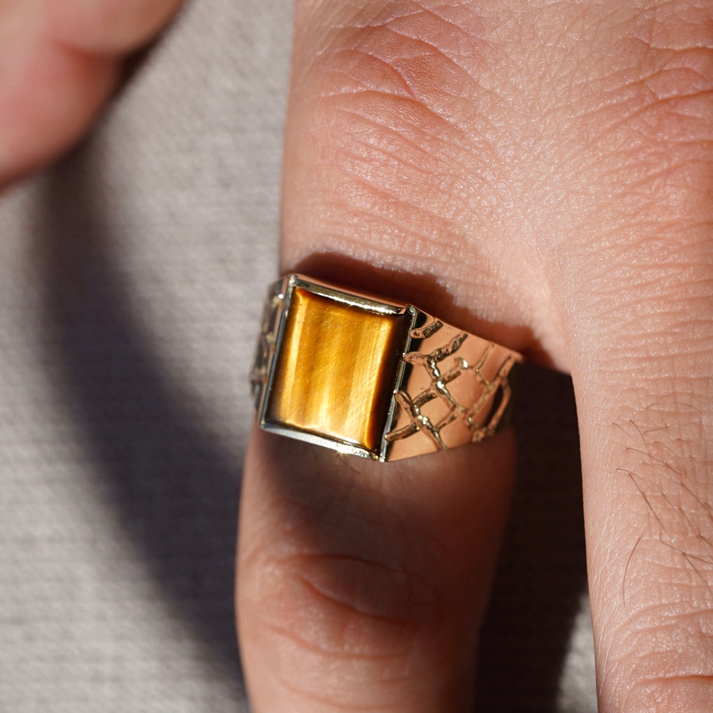 A sophisticated men's 14K gold ring with a 19mm width, worn on the hand of a model. The polished yellow gold catches the light, adding a touch of elegance and confidence to any outfit.
