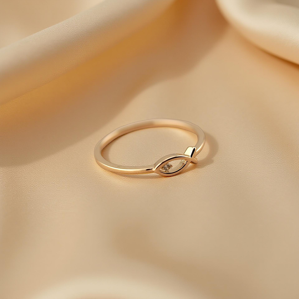 Minimalist Christian fish ring made from solid 14K yellow gold, displayed on a beige cloth with a luxurious golden shine.