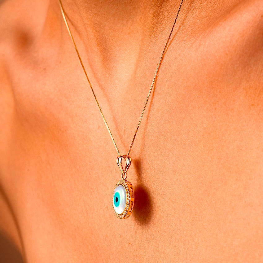 A model showcases the 14K Gold Evil Eye Charm with the vibrant blue eye, elegantly paired with a delicate gold chain for a stylish and protective everyday look.