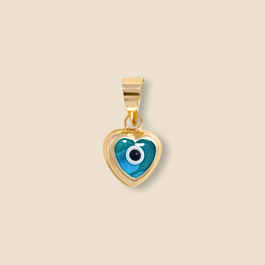 A close-up of the 14K yellow gold heart pendant with a vibrant blue evil eye center, resting on plain background, symbolizing classic protection and offering a minimalist yet bold pop of color.
