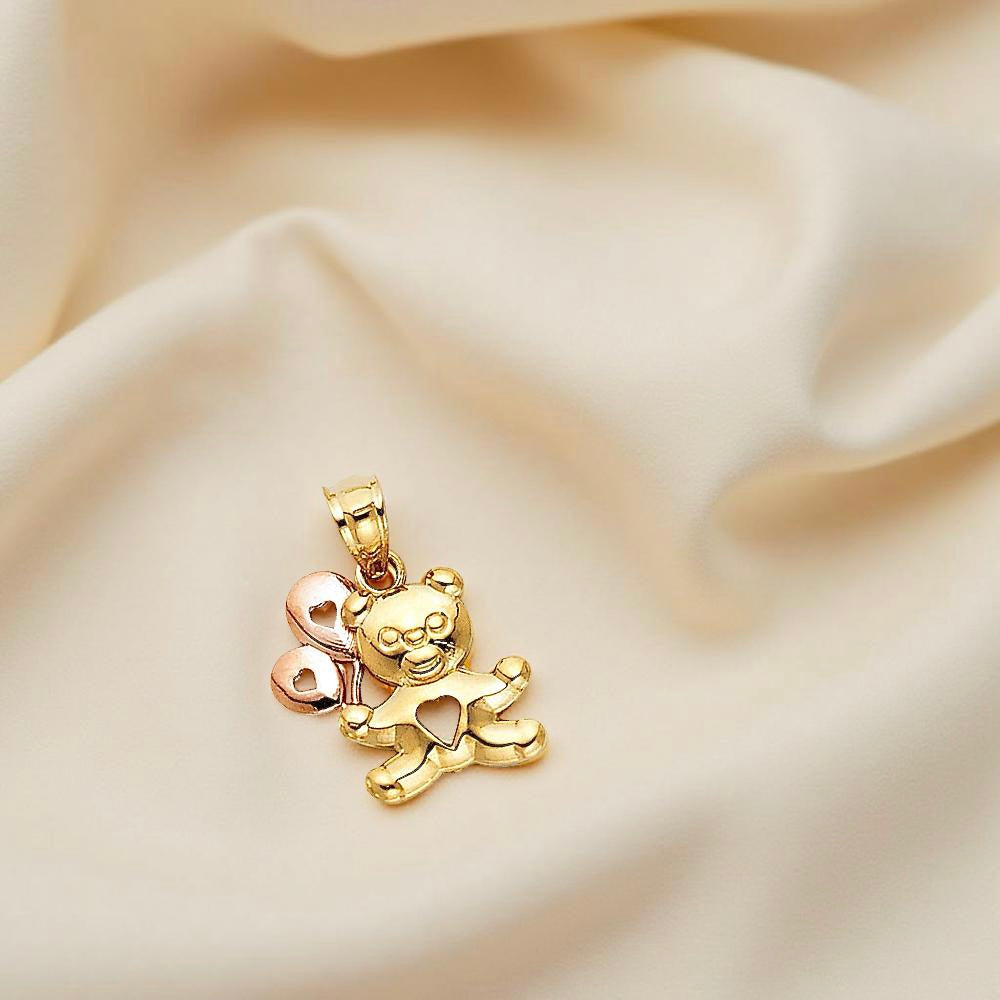 14K gold baby bear pendant with balloon resting on soft off-white cloth, showcasing its polished finish and whimsical design.