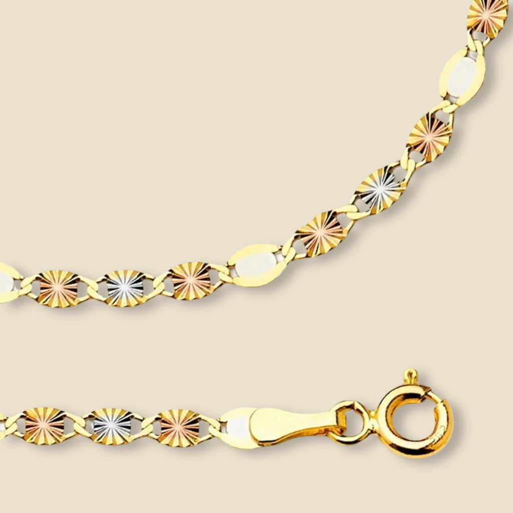 Flat 14K tri-color Valentino star chain necklace laid in a straight line on a plain background, highlighting the shine and elegant diamond-cut star links.