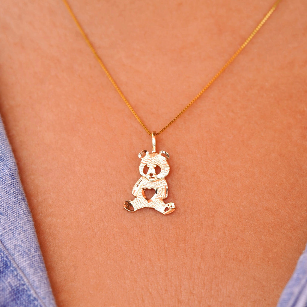 Model wearing a delicate 14K gold panda charm pendant on a chain, highlighting how the dainty design sits elegantly on the neckline, perfect for everyday wear or as a thoughtful gift.