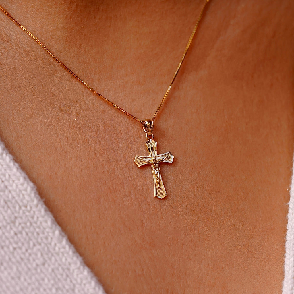 A model wearing the 14K Yellow Gold Crucifix Cross Pendant on a gold chain, highlighting its religious significance and elegant craftsmanship.