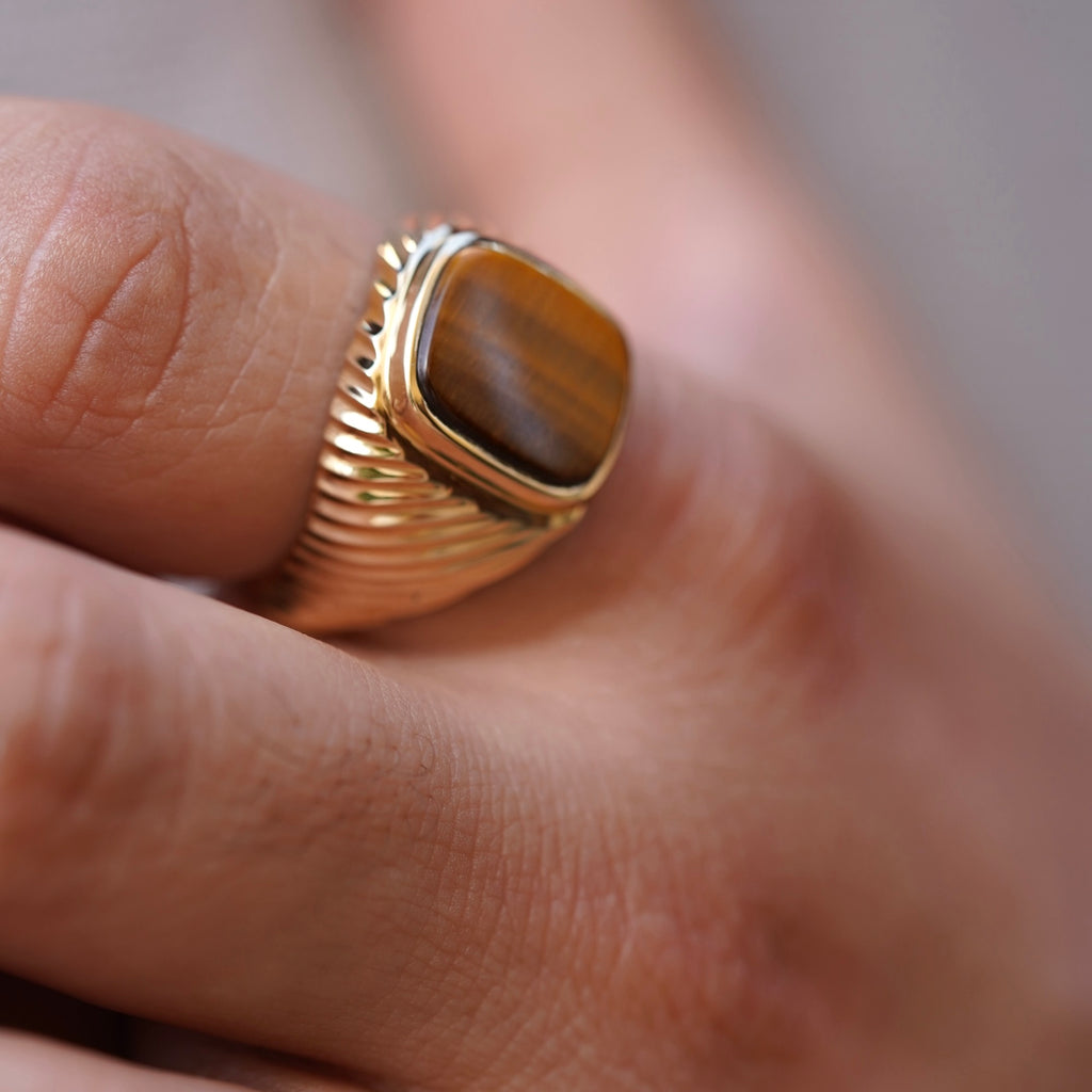 A sophisticated men's 14K gold ring with a 18mm width, worn on a model's hand. The polished yellow gold reflects light, adding elegance and confidence to any look.