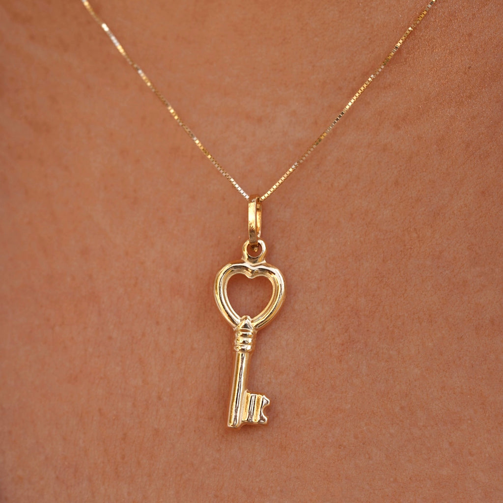A fashionable model elegantly wearing the 14K Real Gold Key Pendant on a gold chain, showcasing its timeless charm and sophisticated style.