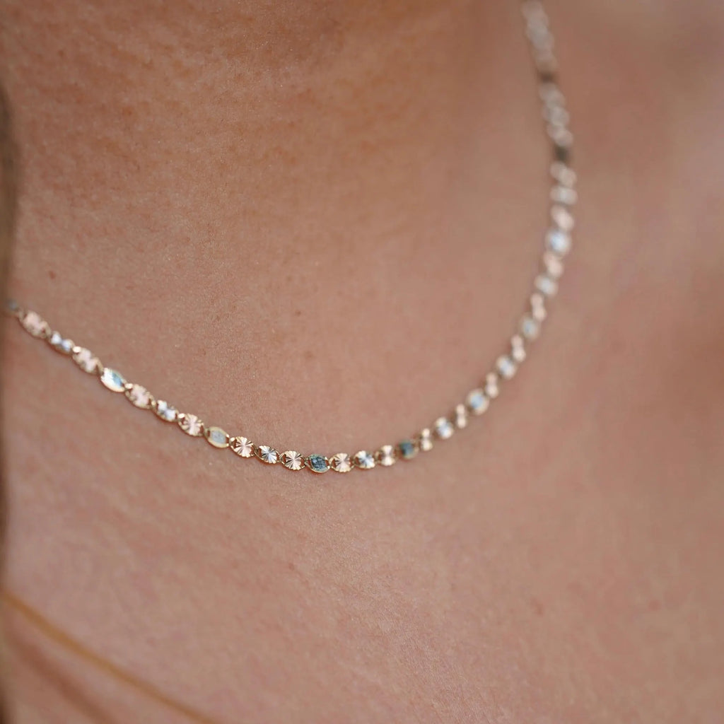A model elegantly wearing the 14K solid gold Valentino chain necklace, showcasing its refined, lightweight design. The 2mm chain drapes gracefully around the neck, highlighting its polished gold shine. Perfect for everyday wear or special occasions, this Italian-made chain exudes timeless sophistication and versatility.