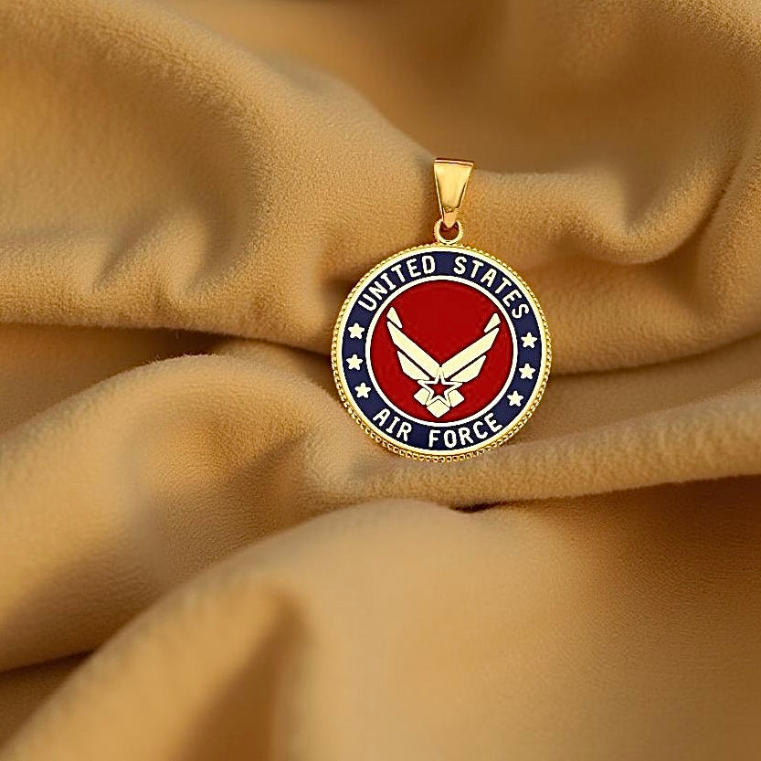 Close-up of US Air Force gold charm on soft cream fabric background, highlighting polished gold finish and fine detail.