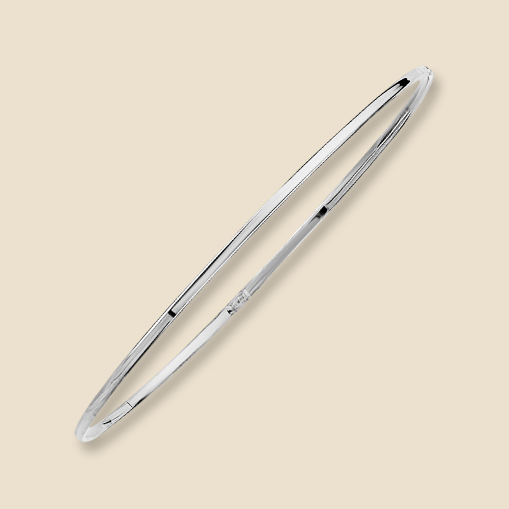 A 14K white gold plain bangle bracelet with a slim 1.5mm width shown on a plain background, reflecting light off its polished gold surface.