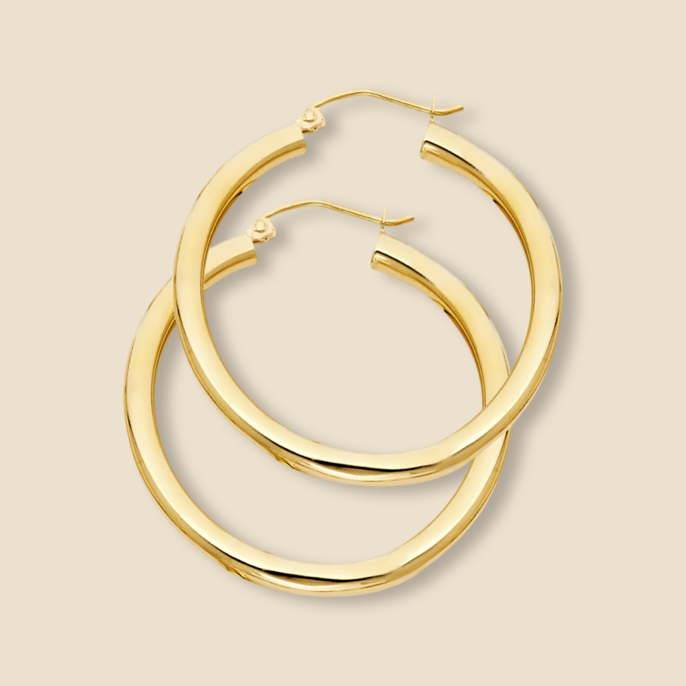 A pair of elegant 14K yellow gold hoop earrings in yellow gold, displayed against a plain background, showcasing their polished finish and timeless design.