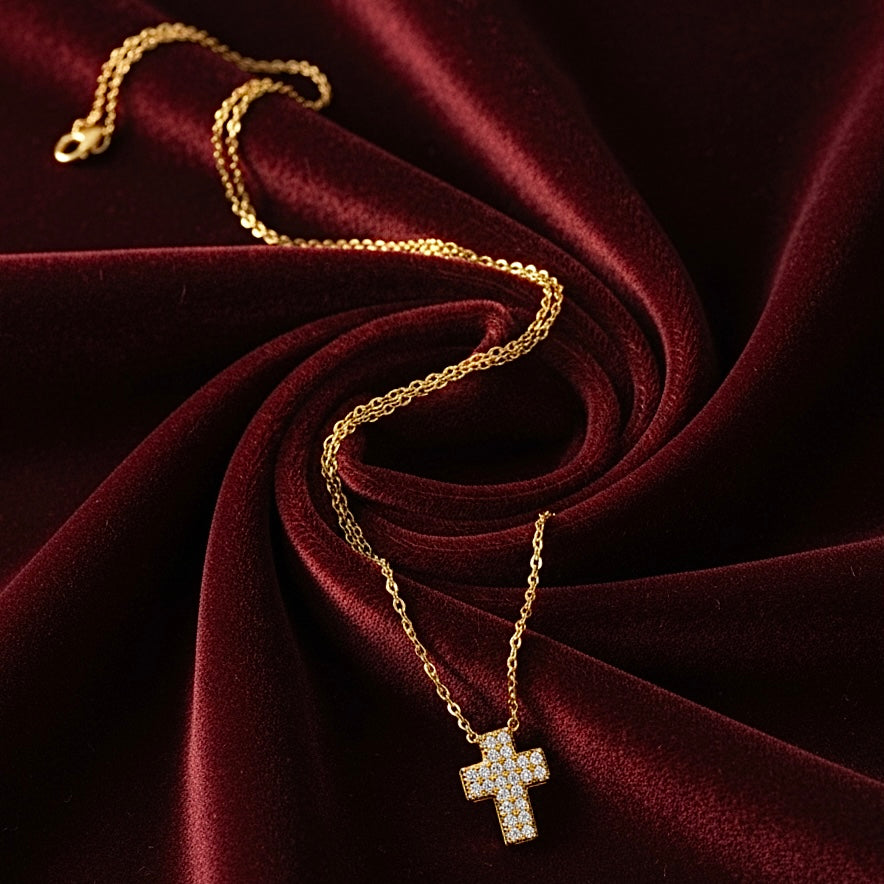 14K Yellow Gold CZ Cross Necklace elegantly placed on rich burgundy velvet, with sparkling cubic zirconia stones catching the light, showcasing a luxurious and refined presentation.