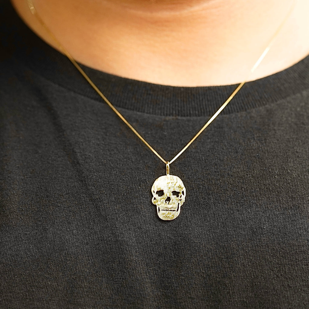 Model wearing a 14K Solid Gold Skull Charm on a gold chain, showcasing its bold and stylish appeal.